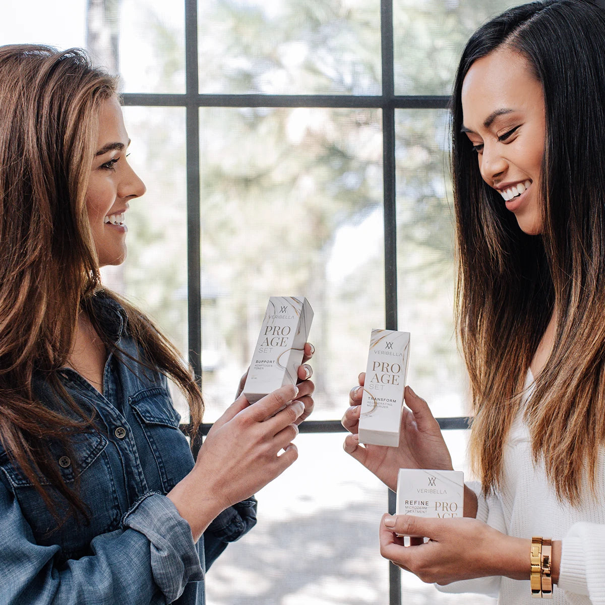 Two women holding bottles of The Pro Set.